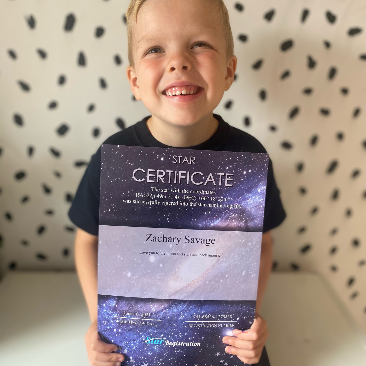 Boy holding his star-registration certificate in the camera